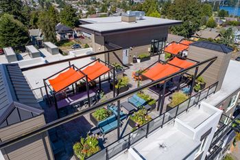 A patio with orange awnings and a glass railing.